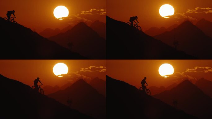 SLO MO锁定的剪影山地自行车手下山对抗戏剧性的橙色天空日落期间