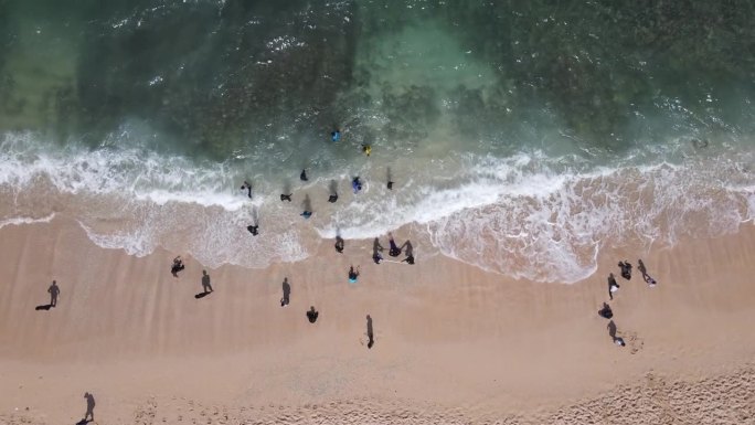 空中无人机拍摄的假期在印尼的古农海滩，有大海、船和人。