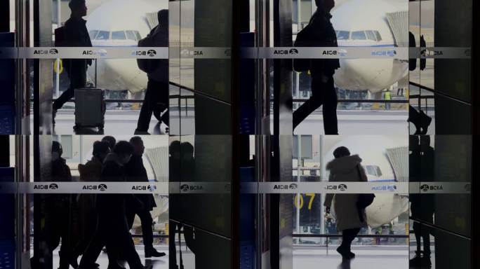 机场的旅客剪影在停场飞机前走动
