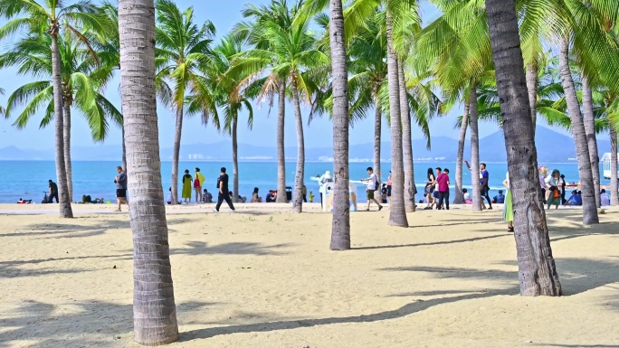 海南三亚西岛蓝天白云下椰树海洋沙滩与游客