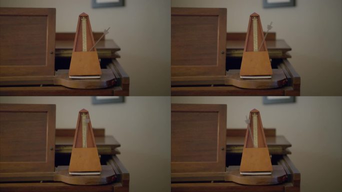 古董木制的老式节拍器通过在一架旧钢琴上每秒来回摆动一次重量来标记每分钟60次