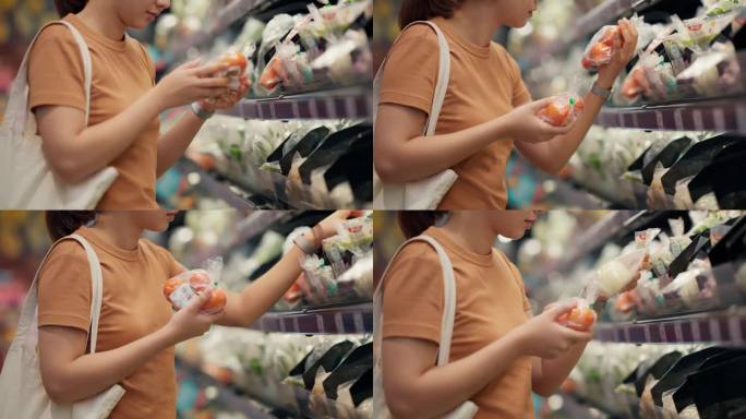 年轻女子在超市买西红柿。
