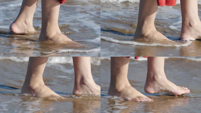女人光着脚踩在海边的沙滩上。