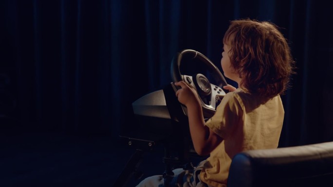 男孩自信地踩下油门踏板，驾驶游戏方向盘，同时观看虚拟赛道
