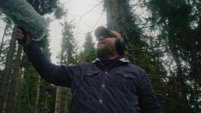 男性旅行者用专业的音频设备记录大自然的声音