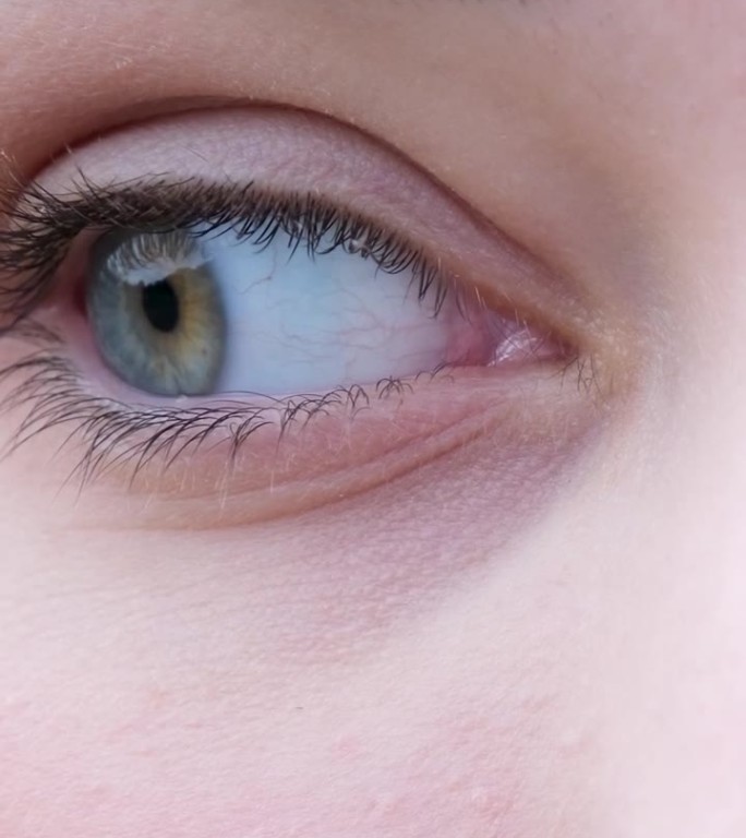 垂直视频用右眼看从右到左瞳孔特写女人绿蓝色眼睛眉毛睫毛浅色皮肤眼保健操检查视力