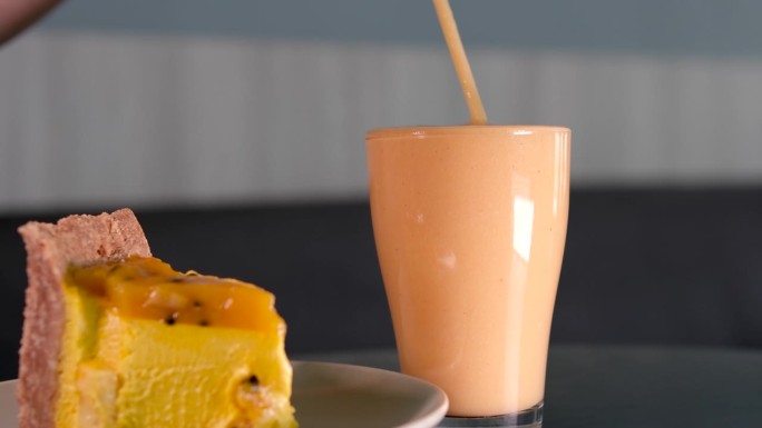 健康芒果奶昔在一个水晶玻璃杯与薄荷叶和芒果在绿色的背景。芒果奶昔。