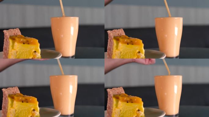 健康芒果奶昔在一个水晶玻璃杯与薄荷叶和芒果在绿色的背景。芒果奶昔。