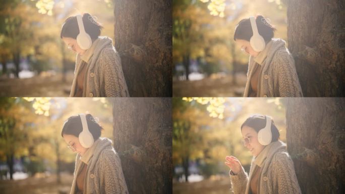 一个亚洲女人倚在树上欣赏秋日美景的慢镜头
