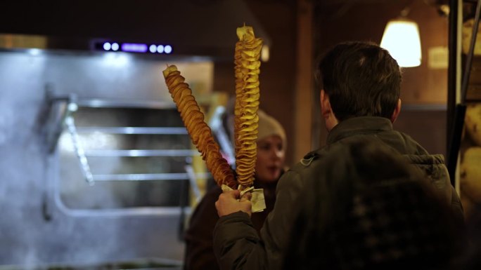圣诞市集售卖螺旋形炸薯片“卷曲薯片”;露天夜市的龙卷风土豆串;用扭曲或龙卷风照片薯片制作街头小吃;薯