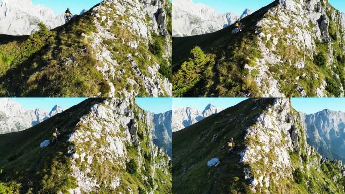 高角度无人机拍摄的决心骑自行车的人在大岩石悬崖的边缘在阳光明媚的一天