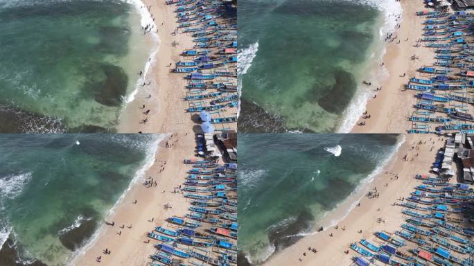 无人机拍摄的印尼日惹海滩上的雨伞、船只和度假的人们