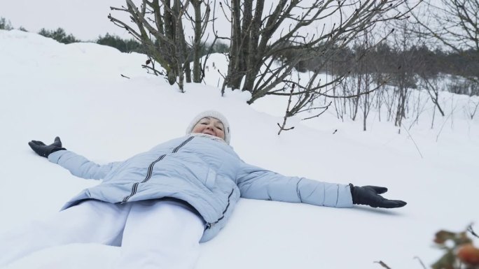 一位老妇人高兴地跌倒在雪地里