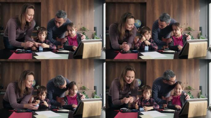 孩子和家长使用彩色纸做折纸玩具，按照在数码平板电脑上的视频教程指示的步骤