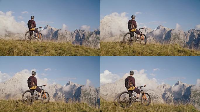 SLO MO无人机拍摄的男性骑自行车的人坐在自行车对落基山脉在阳光明媚的一天