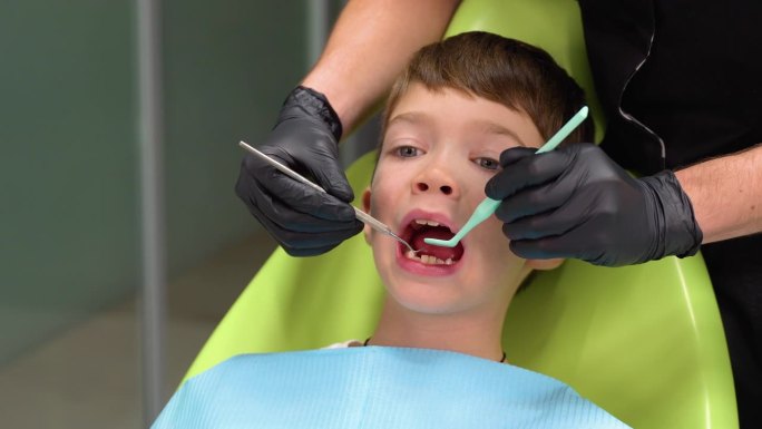 小男孩在牙医治疗牙齿时张大嘴巴的特写