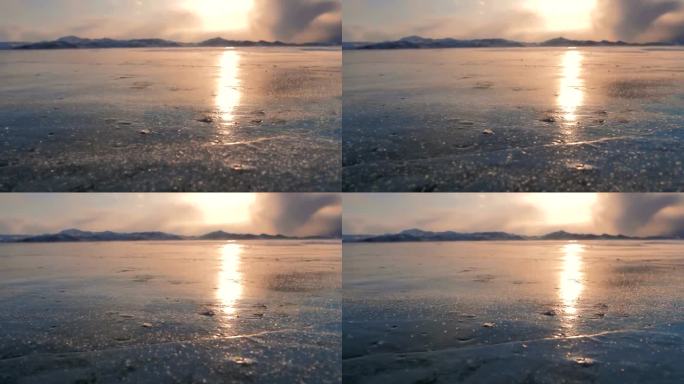 日落时分，强风吹着贝加尔湖结冰的表面上的雪晶，太阳反射在冰面上。美丽的冬季景观。