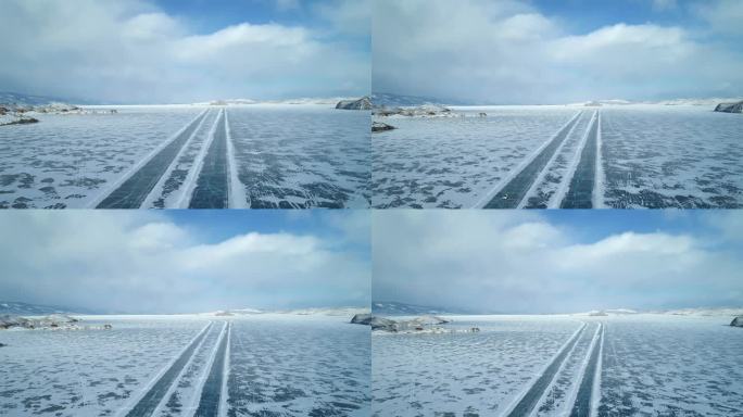 冬季贝加尔湖冰面上的鸟瞰图。结冰的道路上行驶着汽车。冬天的风景。飞越冰冻的贝加尔湖。