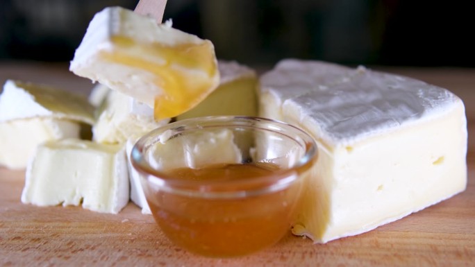 布里奶酪。卡蒙伯尔的奶酪。新鲜的布里干酪和一片放在木板上，配上坚果、蜂蜜和树叶。意大利奶酪，法国奶酪