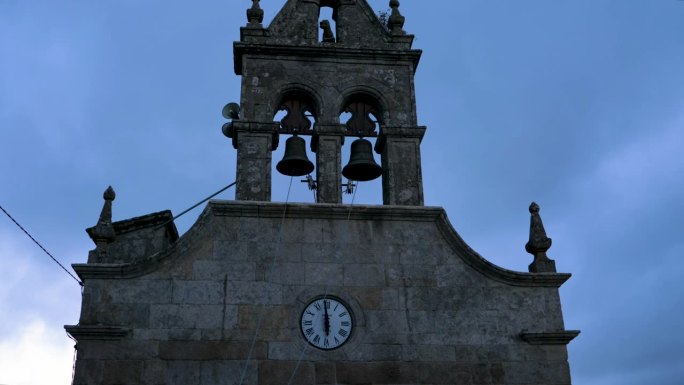 无人机从苔藓覆盖的石像鬼和钟楼上撤退，展现了西班牙欧伦斯的广阔景观