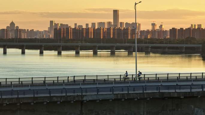 夕阳跨河大桥骑车意境感航拍素材