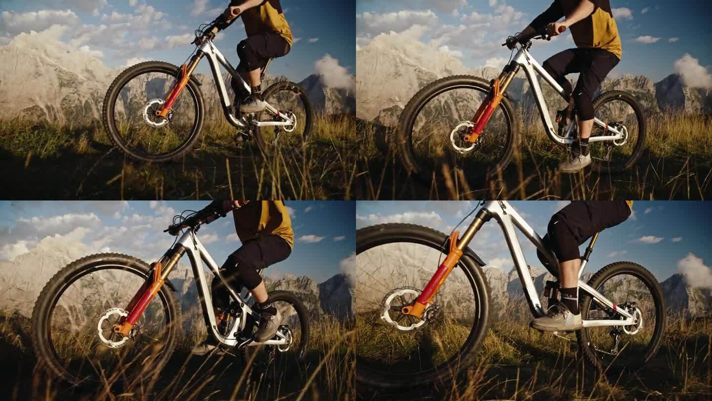 在阳光明媚的日子里，山地自行车手在草地上骑自行车对抗落基山脉