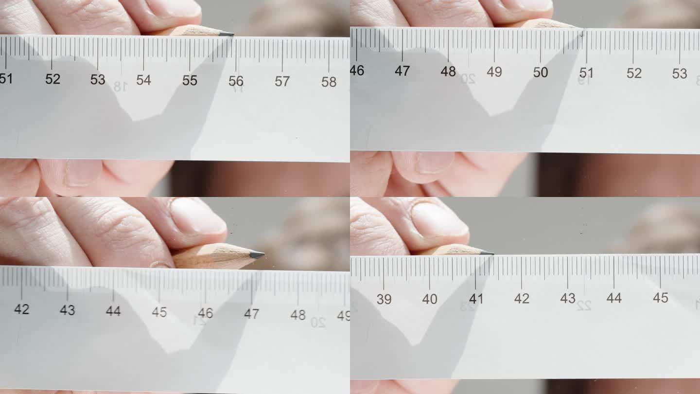 测量尺寸，特写一个人用铅笔做记号。厘米尺。低角度视角聚焦于玻璃