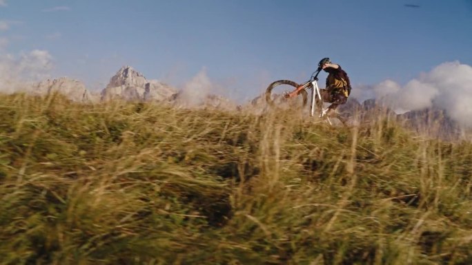 SLO MO的地面水平手持拍摄的决心骑自行车的车轮表演与自行车在草地上