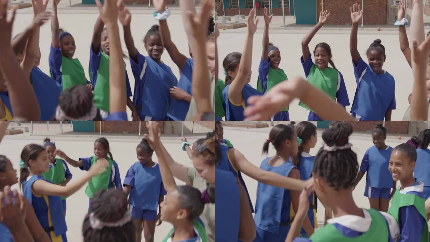 女生们开始练习篮球时，聚在一起，举起手来，展现团队精神