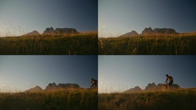 SLO手持拍摄的决心山地自行车骑自行车在草地上对晴朗的天空在日落