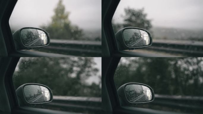 汽车在雨中行驶，镜中有雨滴和模糊的山林背景，慢动作