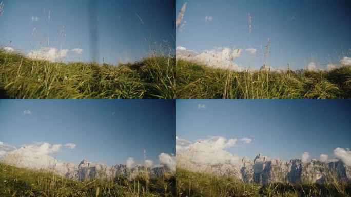 跟踪拍摄草地和田园诗般的落基山脉对蓝天在白天