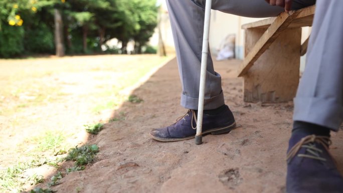 一个盲人的脚举着拐杖的特写