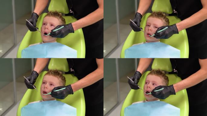 悲伤的小男孩在牙医治疗牙齿时张大了嘴巴