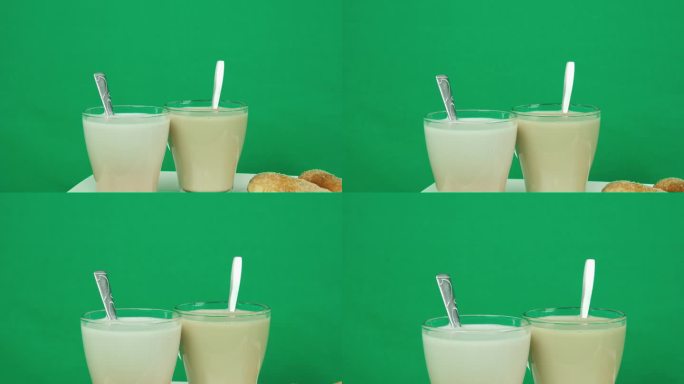 广告绿色背景镀铬复制空间两杯拿铁咖啡和一个牛角面包在桌子上。餐馆街头小吃的生活方式。