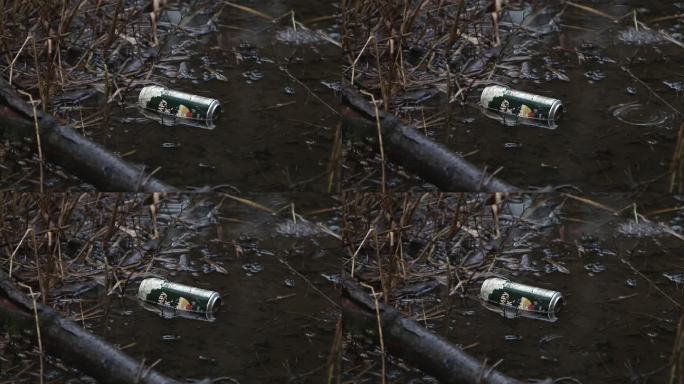 废弃的铝饮料会在雨中漂浮在池塘边。冬天。英国