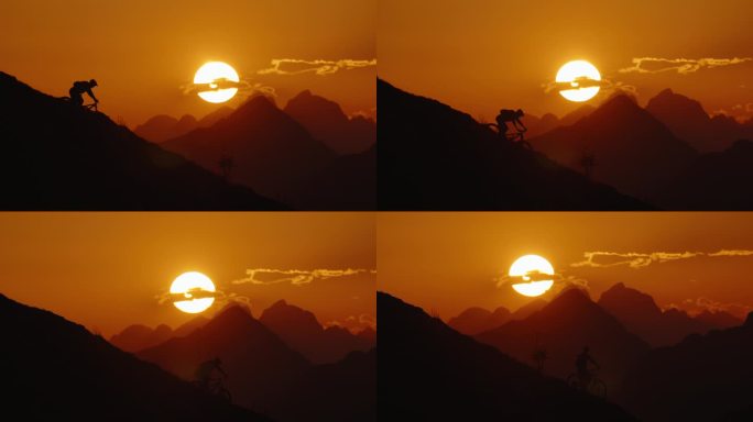 SLO - MO手持拍摄的决心剪影山地自行车运动下坡对戏剧性的橙色天空在日落。极端山地自行车在危险的