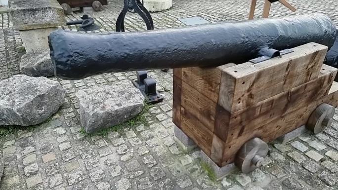 在英国鹅卵石路面上展示的锻铁木制大炮