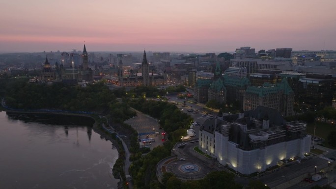 这是渥太华市中心清晨的无人机倒转镜头，显示了包括司法大楼、和平塔和最高法院在内的城市天际线