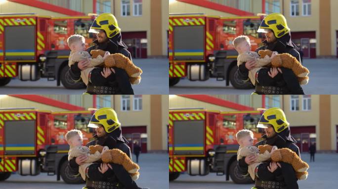 勇敢的消防员站在消防车旁，把获救的男孩抱在怀里