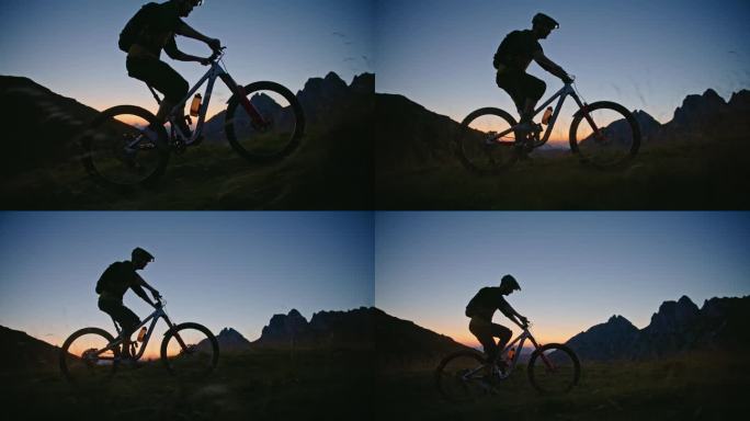 SLO MO侧面视图骑自行车的男子在草地上对着清澈的蓝天在黄昏