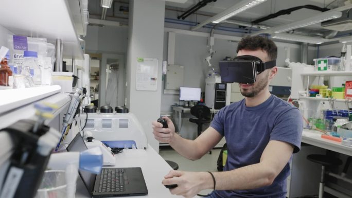 男科学家在实验室里使用虚拟现实眼镜的原型