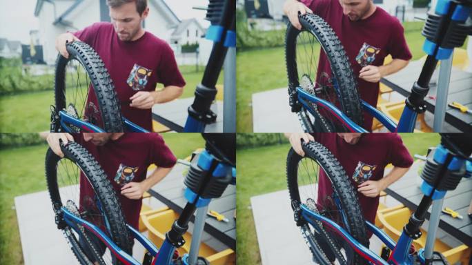 在院子里修理山地车轮胎的中年男子手持镜头