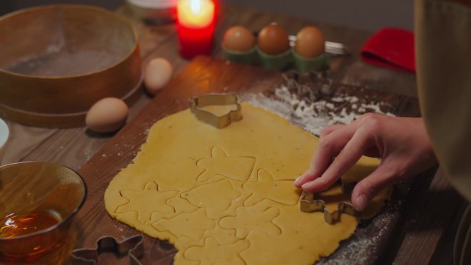 在厨房里，一位穿着家常衣服的年轻面包师正在制作五彩缤纷的新年饼，展示她的手艺
