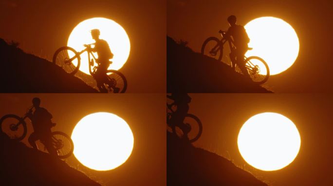 SLO MO剪影山地自行车手推自行车，而在山上移动对雄伟的太阳在晴朗的天空在日落期间