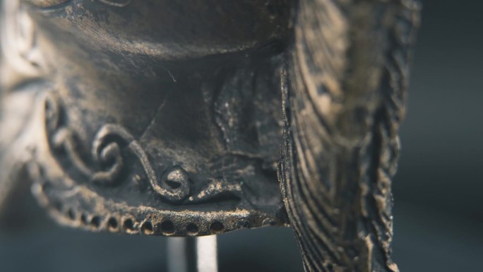 一个近距离的微距细节拍摄从斯巴达的脸设计，战士古希腊青铜头盔，在一个360度旋转的支架，工作室照明，