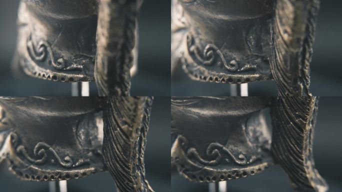 一个近距离的微距细节拍摄从斯巴达的脸设计，战士古希腊青铜头盔，在一个360度旋转的支架，工作室照明，