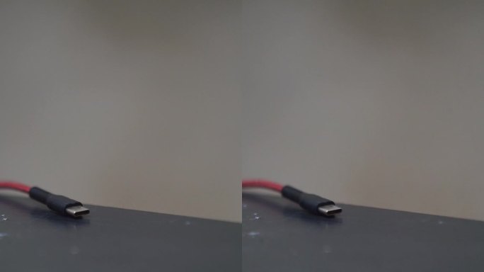 C型插头，红色电缆放在黑色的桌子上