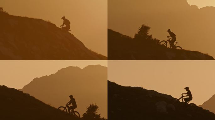勇敢的男子山地自行车攀登岩石山在明亮的薄雾日落
