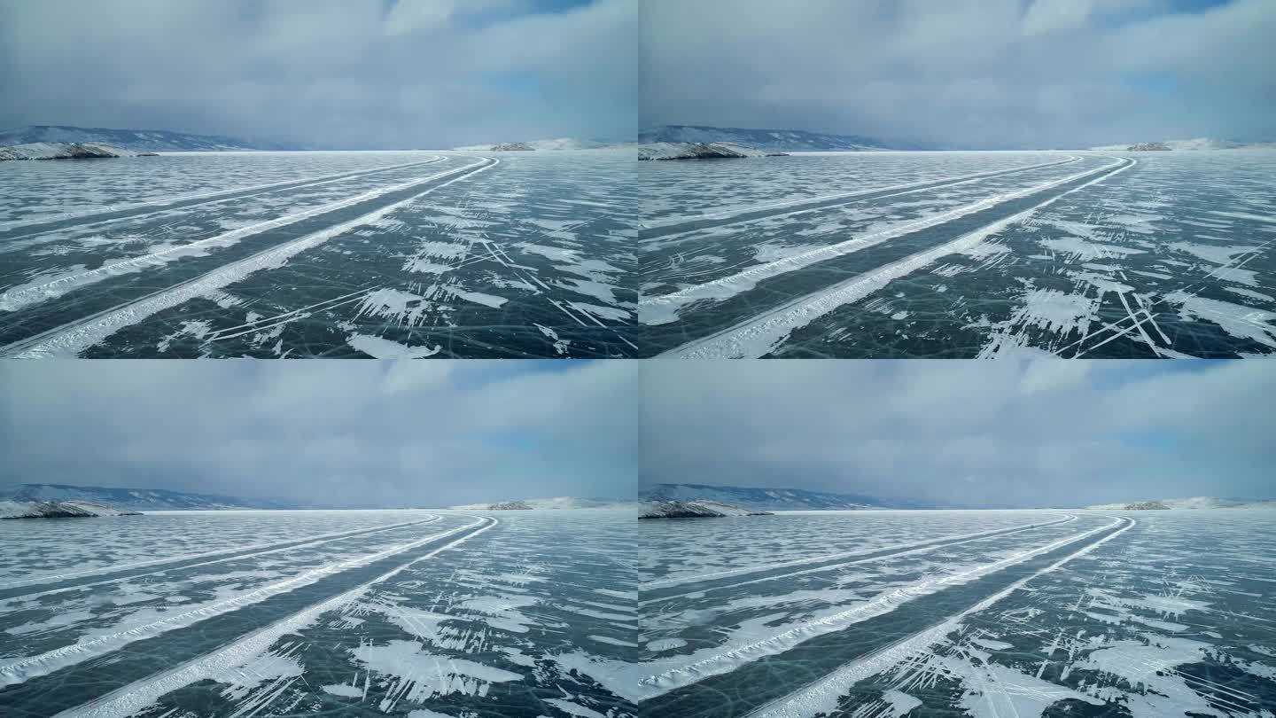 冬季贝加尔湖冰面上的鸟瞰图。结冰的道路上行驶着汽车。冬天的风景。飞越冰冻的贝加尔湖。